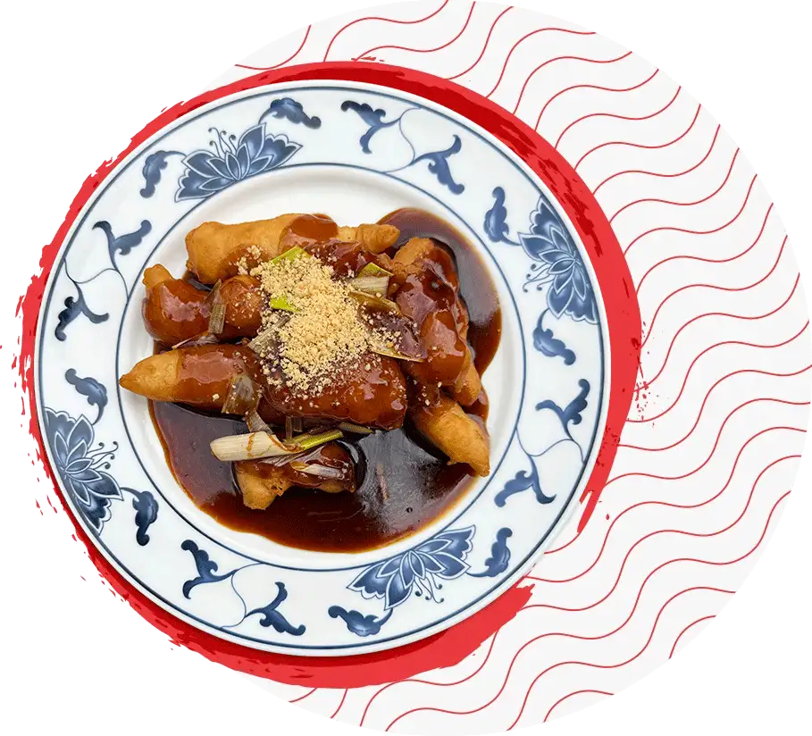 Gericht in dunkler Sauce mit Erdnüssen und Frühlingszwiebeln